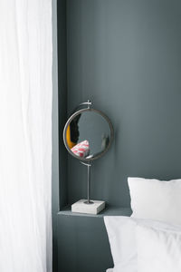 The mirror is on the bedside table in a minimalist bedroom