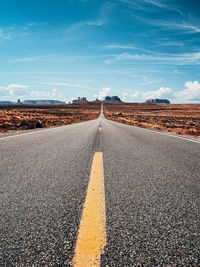 Road amidst desert landscape against sky