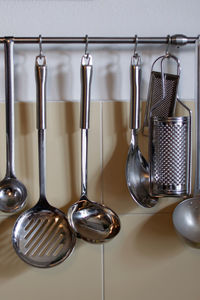 Close-up of utensils hanging on hooks in kitchen