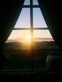 Airplane wing against sky during sunset