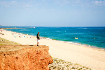 Man standing on beach against sky