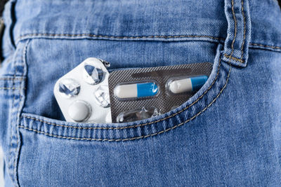 Close-up of medicines in jeans pockets