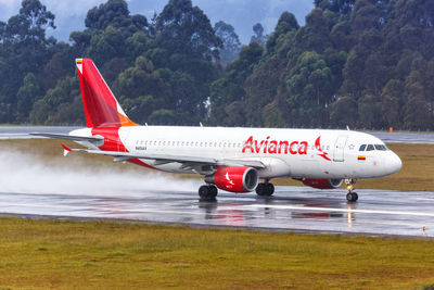 Side view of airplane on runway against sky