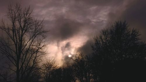 Low angle view of bare tree against cloudy sky