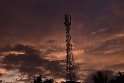 Low angle view of silhouette communications tower against sky during sunset