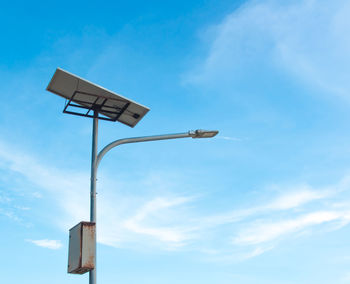 Low angle view of street light against blue sky