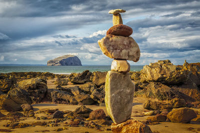 Stack of rocks on beach against sky