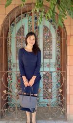 Portrait of smiling young woman standing against built structure