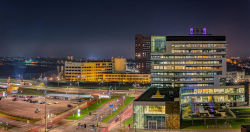 High angle view of illuminated buildings against sky at night