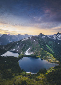 Scenic view of lake and mountains against sky during sunset