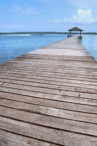 Pier on beach against sky