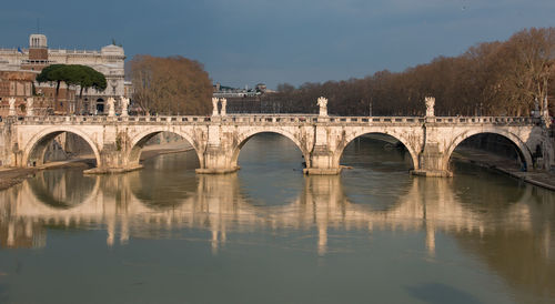 Arch bridge over river against sky