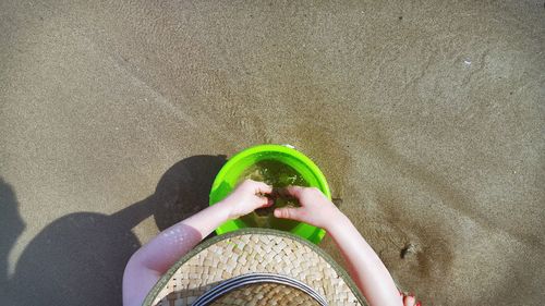 Cropped image of boy with bucket at beach