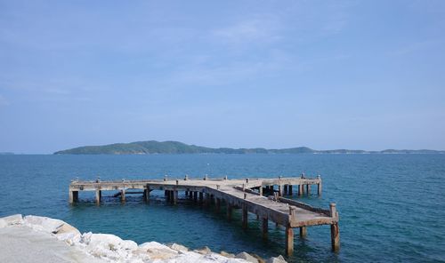 Pier over sea against blue sky