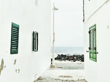 Buildings by sea against clear sky