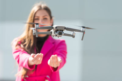 Portrait of woman standing by drone outdoors