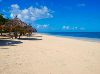 Scenic view of beach against blue sky