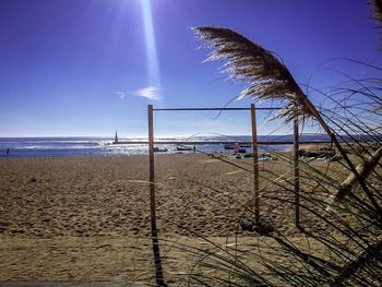 View of calm beach against blue sky