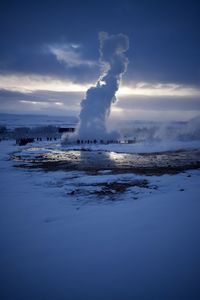 Scenic view of hot spring against cloudy sky during winter
