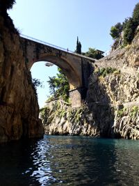 Arch bridge over river against clear sky