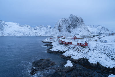 Scenic view of snowcapped mountains by sea against sky