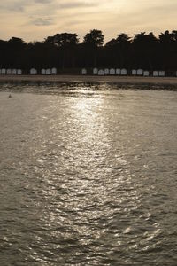 Scenic view of river against sky at sunset