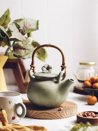 Green ceramic teapot on the table. brightmood stilllife photography