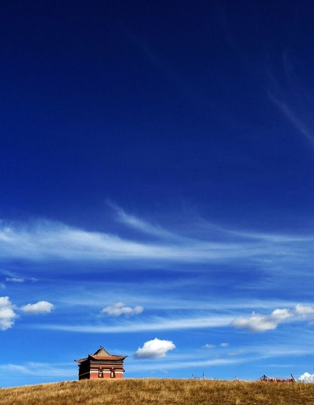 built structure, building exterior, architecture, sky, blue, house, cloud - sky, landscape, cloud, nature, tranquil scene, tranquility, roof, day, beauty in nature, low angle view, sunlight, outdoors, residential structure, field