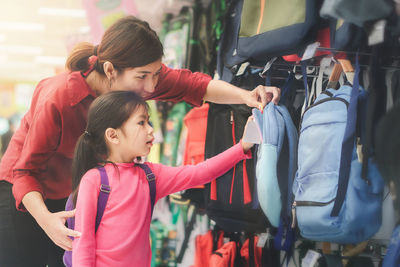 Rear view of mother and daughter at store