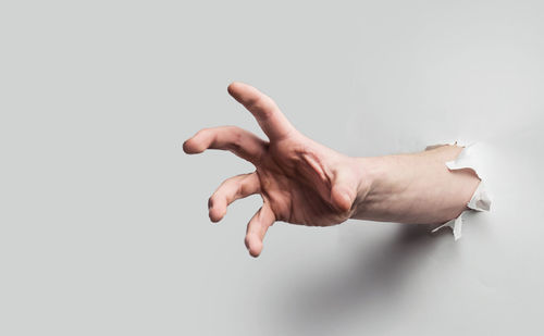 Close-up of person hand against white background