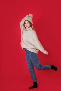 Portrait of woman against red background