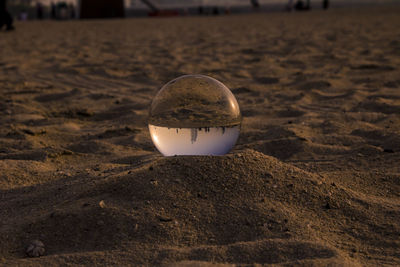 Close-up of crystal ball on sand