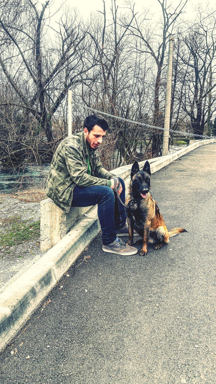 FULL LENGTH OF MAN SITTING WITH DOG ON BENCH