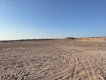 Scenic view of desert against clear blue sky