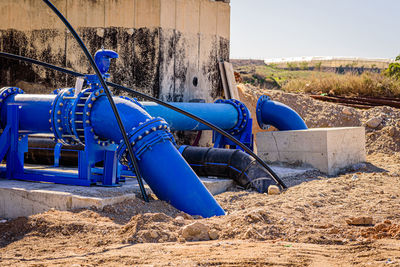 Abandoned construction site on field against clear blue sky