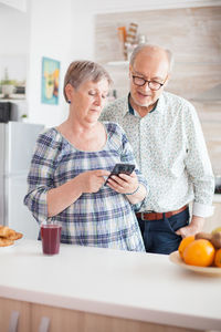 Senior couple using phone at home