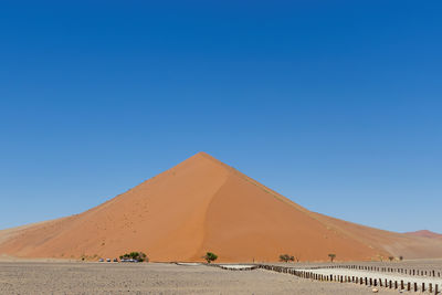 Scenic view of desert against clear blue sky