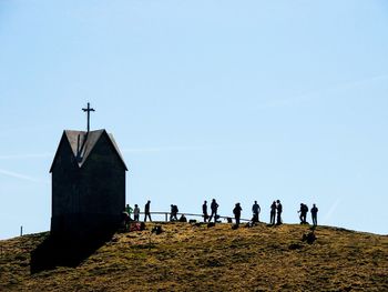 Group of people on beat little church against clear sky in monte grappa