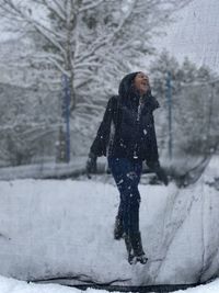 Woman standing on snow covered tree