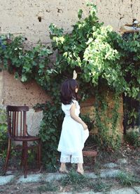 Woman touching plants while standing on field