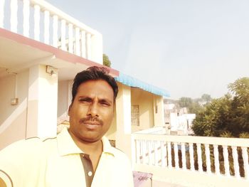 Portrait of young man against building