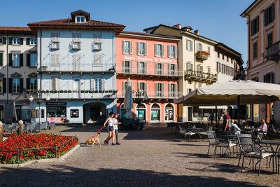 People on street against buildings in city