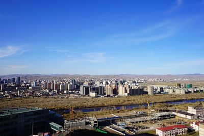 High angle view of buildings against blue sky