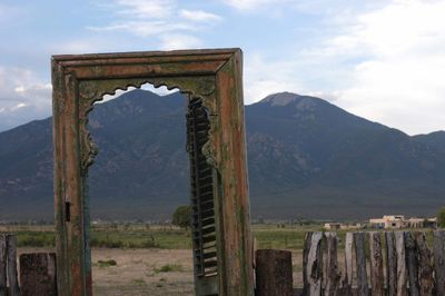 Scenic view of old door and mountains against sky