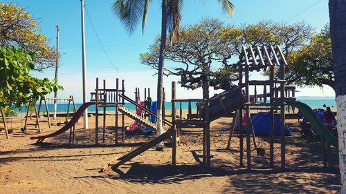Playground on beach against sky
