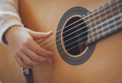 Little girl plays the guitar.