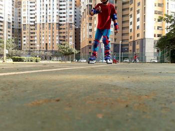 Man skateboarding on street against buildings in city