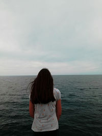 Rear view of woman looking at sea against sky