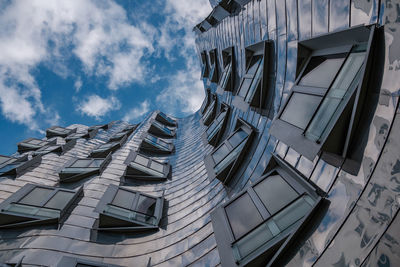 Exterior windows align on reflected metal curvature facade at madiahafen.