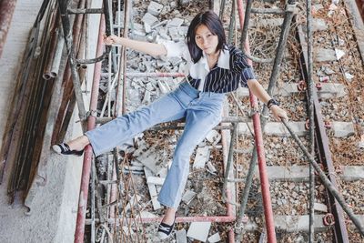 High angle view of girl hanging on metallic rod outdoors